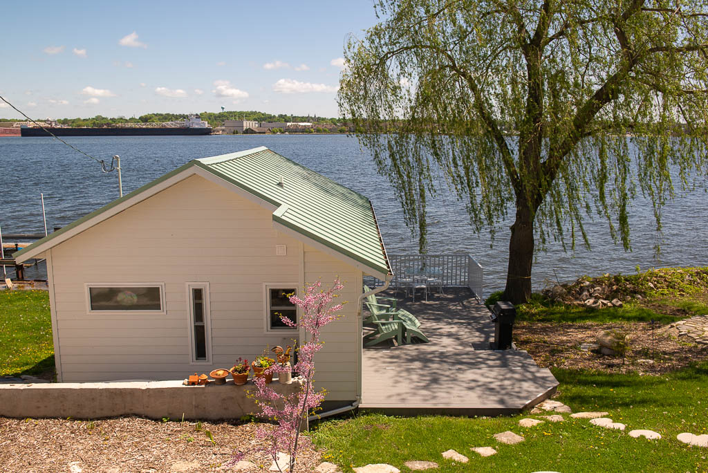 Sidewalk view of Lily Pad Cottage with Redbud in bloom.