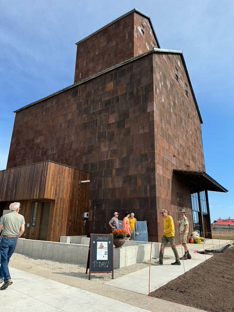 Phil Biebl (yellow shirt) gives tours to visitors the day of the Soft Opening of the Door County Granary.